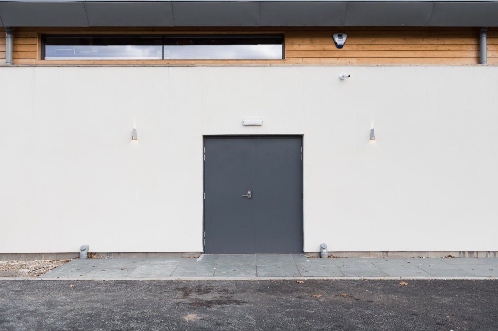 Grey steel security door set into a white wall