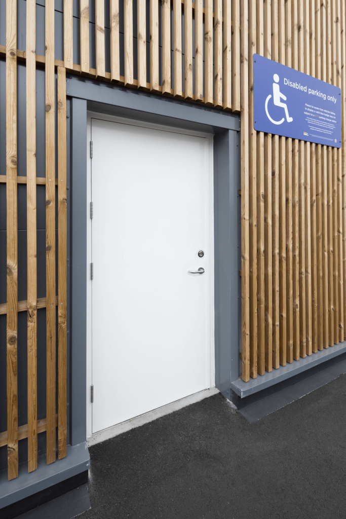 White steel security door with accessible entrance signage
