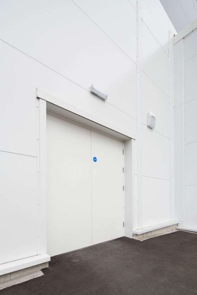 Grey steel security door in a plain wall