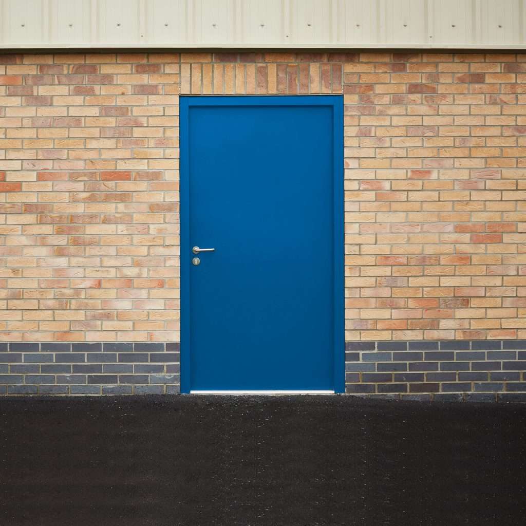 Blue steel personnel door in a brick wall