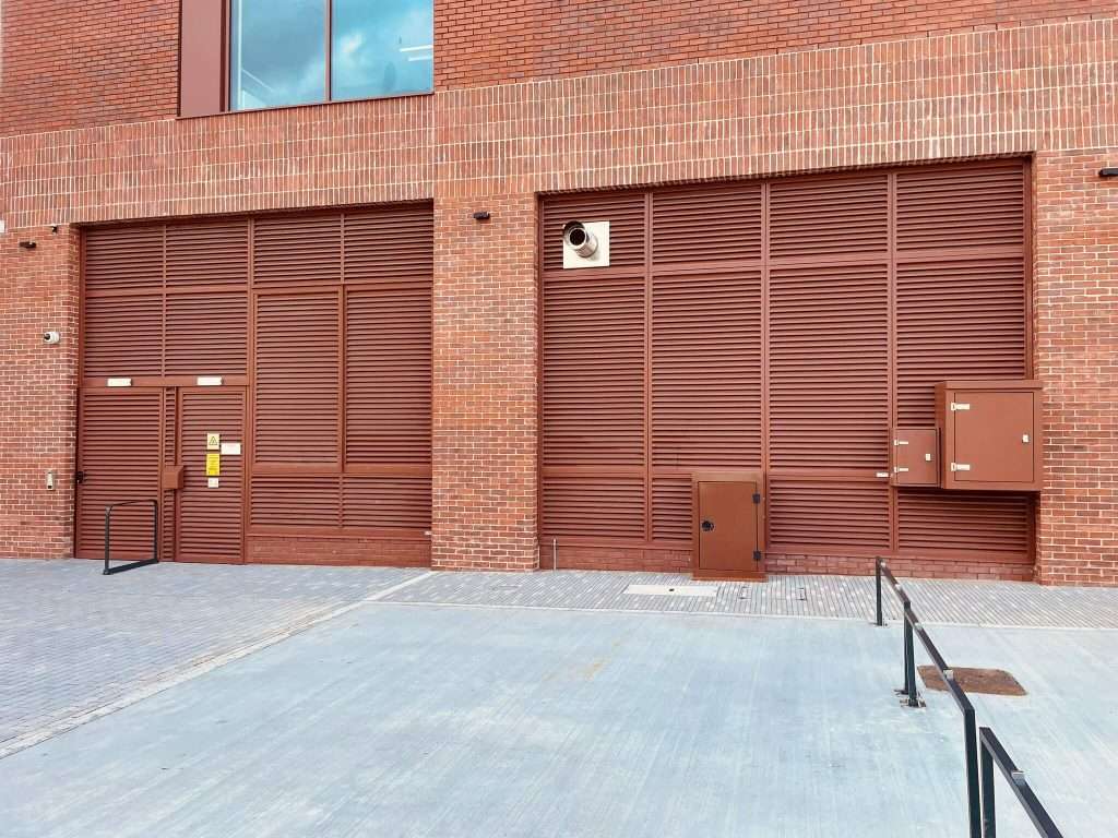 Brick building with steel roller shutter door and entrance path