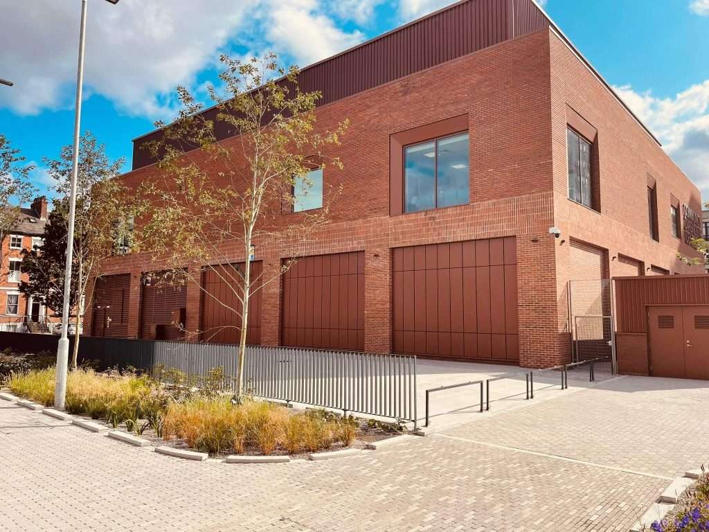Rust-coloured steel roller shutter door recessed into a brick building