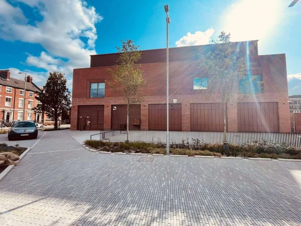 Rust-coloured steel roller shutter door recessed into a brick building